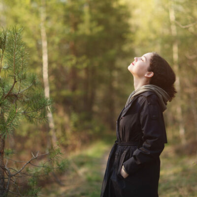 girl woman walking in nature park forest and breathing fresh air. concept of breathing, inhaling, relaxing.